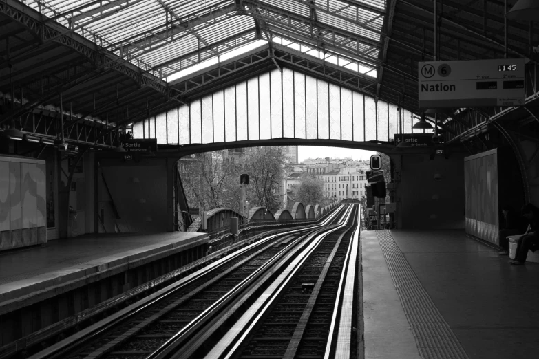 a black and white photo of a train station, by Joan Tuset, flickr, paris, square, view from the back, nuri iyem