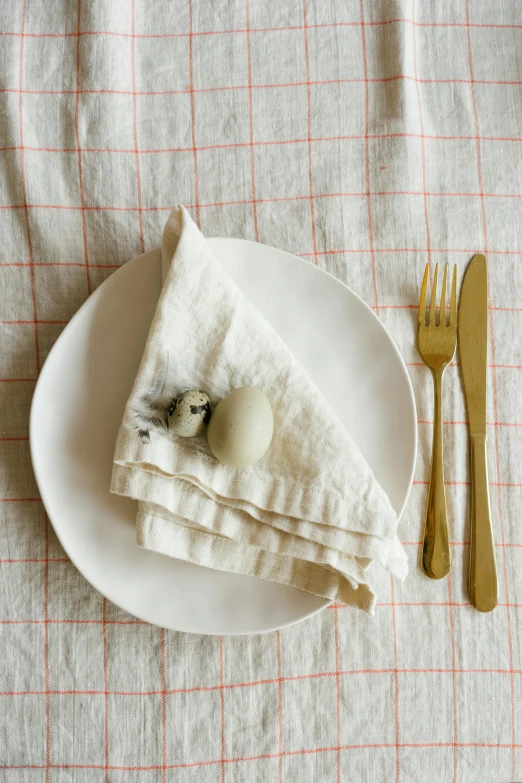 a white plate topped with a piece of cloth, by Jessie Algie, unsplash, square, an egg, place setting, grid