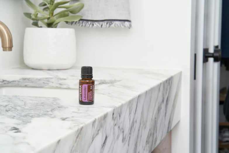a bottle of essential oil sitting on a bathroom counter, by Winona Nelson, brown and magenta color scheme, miniature product photo, made of marble, eye - level medium - angle shot