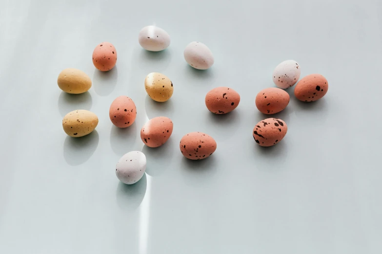 a bunch of eggs sitting on top of a table, varying dots, miniature product photo, subtle color variations, vanilla