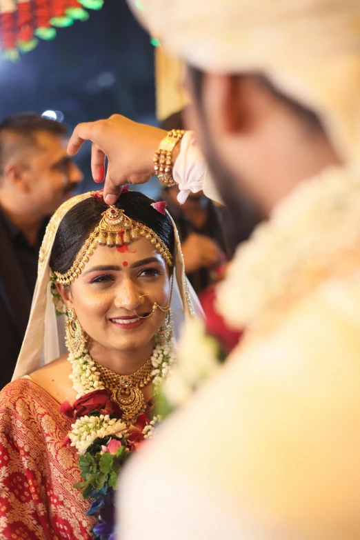 a man putting a necklace on a woman's head, by Sudip Roy, reddit, ceremony, dynamic closeup, square, ready