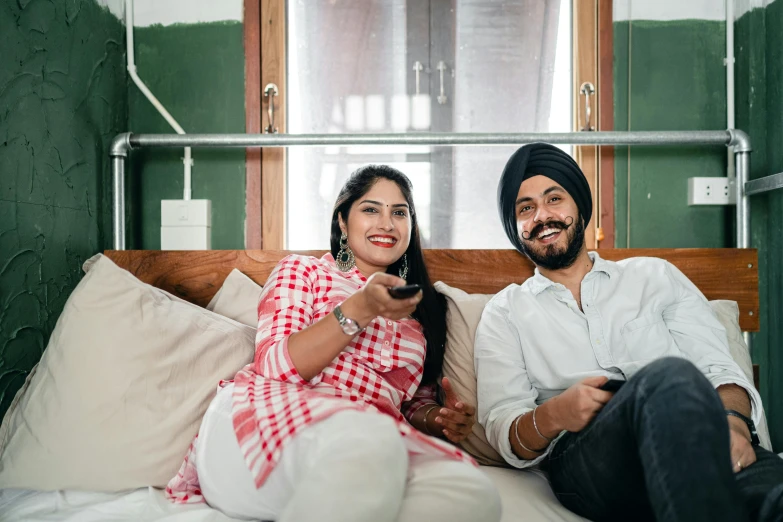 a man and a woman sitting on a bed, a portrait, by Manjit Bawa, pexels, watching tv, both smiling for the camera, avatar image, maintenance