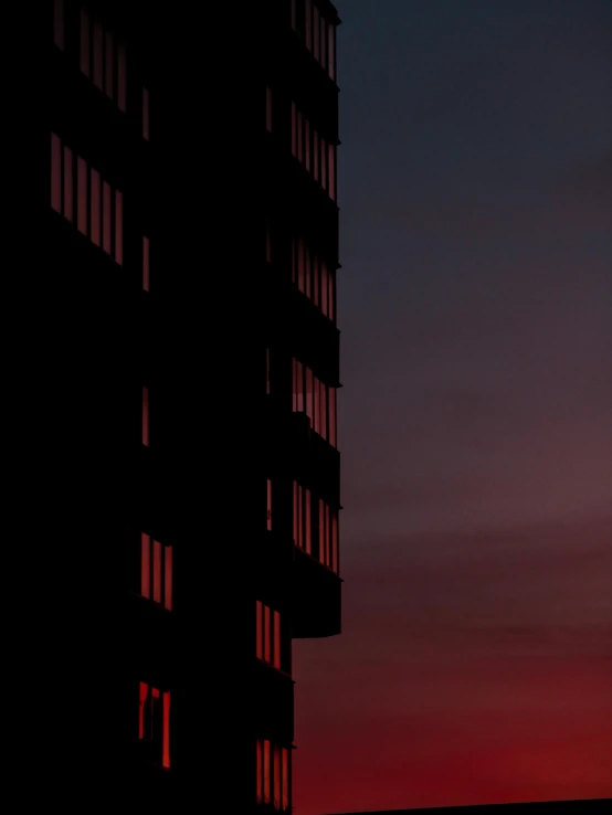 a couple of tall buildings sitting next to each other, by Sebastian Spreng, minimalism, red glow in sky, ((sunset)), low detail, dark