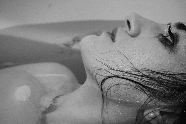 a black and white photo of a woman in a bathtub, by Emma Andijewska, pixabay, process art, dreaming of kissing a girl, closeup of face melting, ffffound, photorealistic art