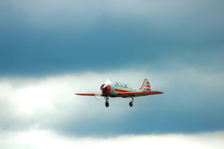 a red and white plane flying through a cloudy sky, by David Simpson, pexels contest winner, preserved historical, micro - hurricane, basil flying, plain background