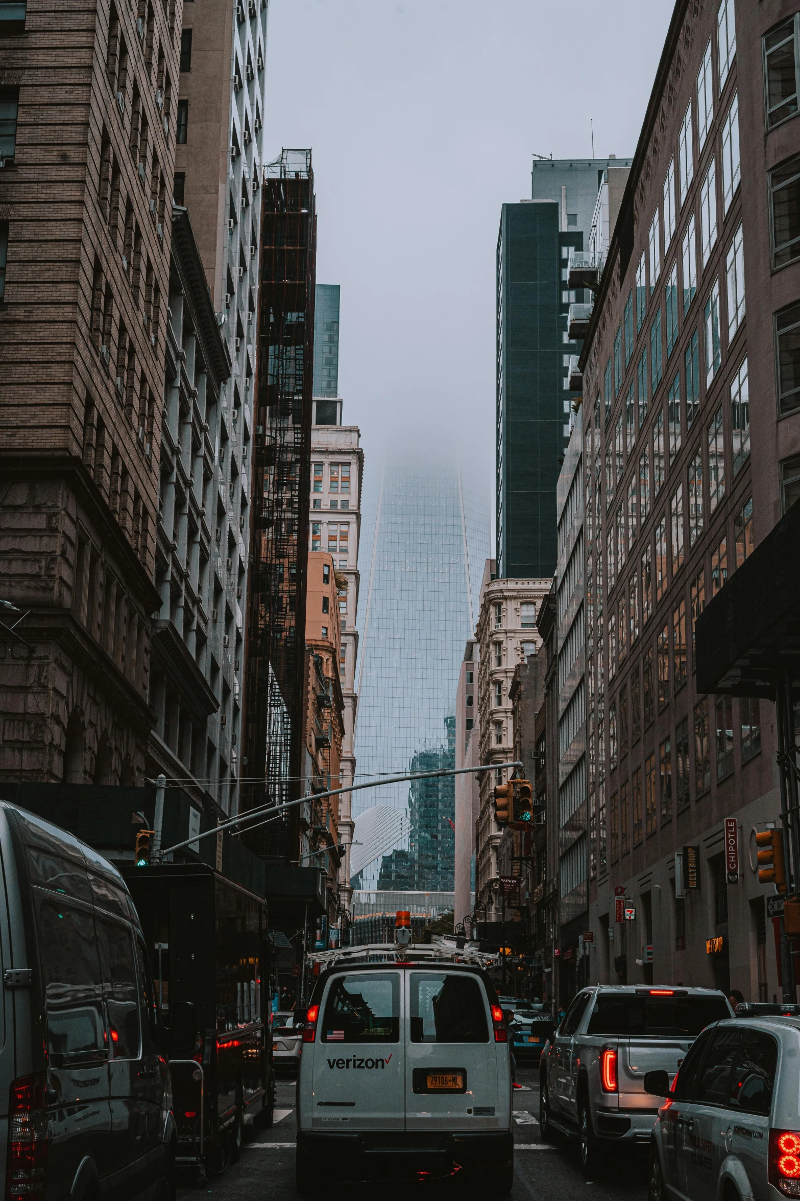 a street filled with lots of traffic next to tall buildings, a picture, unsplash contest winner, new york alleyway, gray skies, instagram story, background image