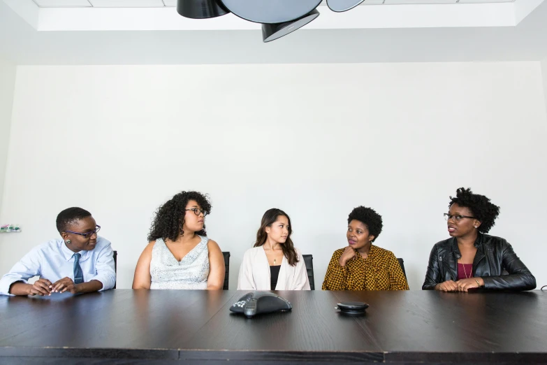 a group of people sitting around a table, profile image, black female, professional photo, thumbnail