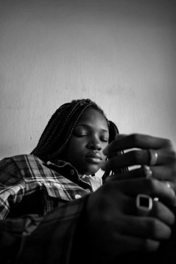 a black and white photo of a woman holding a cell phone, by Chinwe Chukwuogo-Roy, black teenage boy, resting, digital media, a man