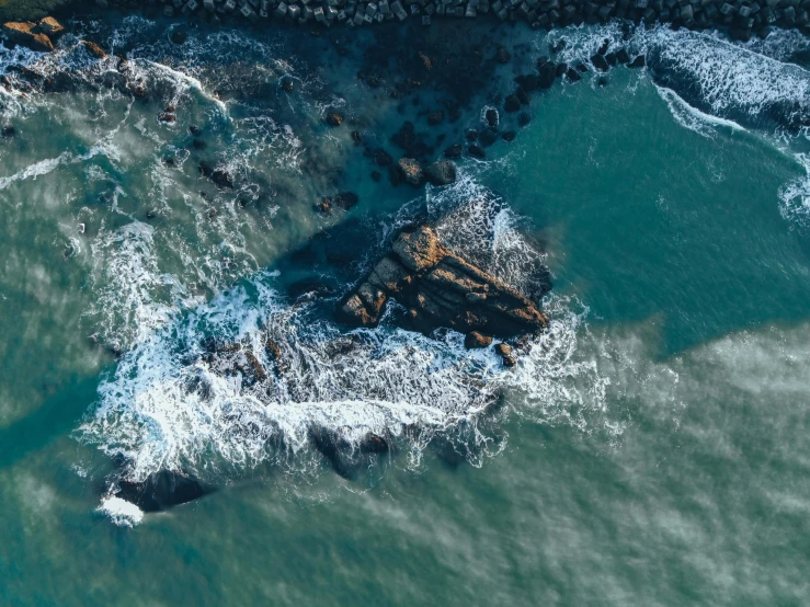 an aerial view of a large body of water, pexels contest winner, waves crashing at rocks, oil spill, thumbnail, high quality image