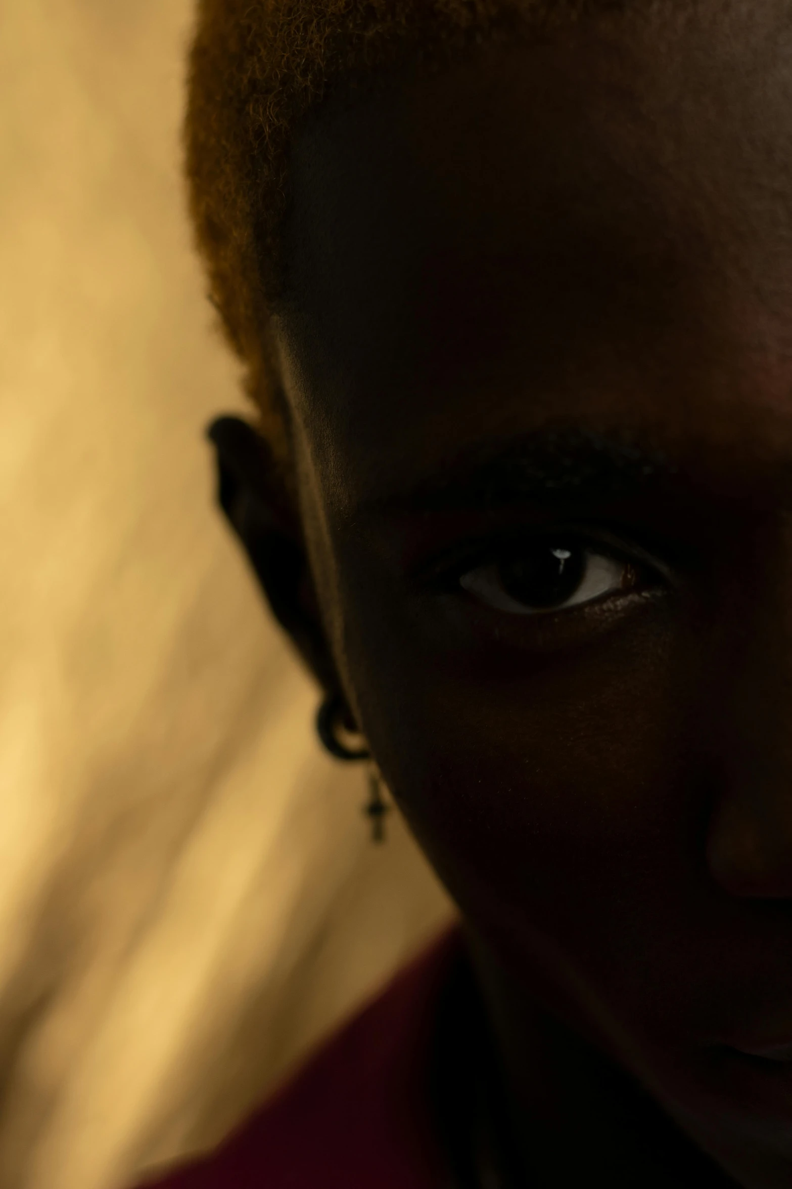 a close up of a person with a cell phone, by Nathalie Rattner, trending on unsplash, afrofuturism, blonde boy with yellow eyes, samburu, dramatic soft shadow lighting, dramatic lighting; 4k 8k