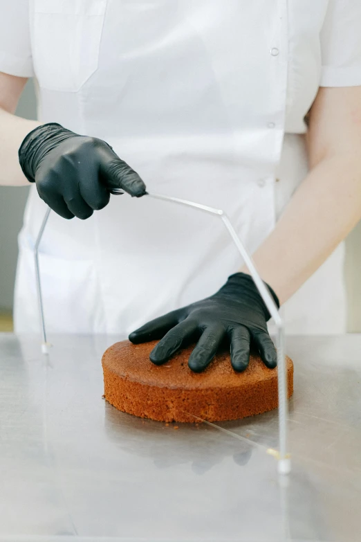 a woman in a white shirt and black gloves cutting a cake, by Alison Watt, pexels, visual art, silicone skin, creating a thin monolith, bakery, transparent