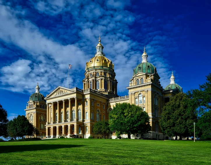 a large building sitting on top of a lush green field, baroque, capitol building, golden towers, profile image, iowa