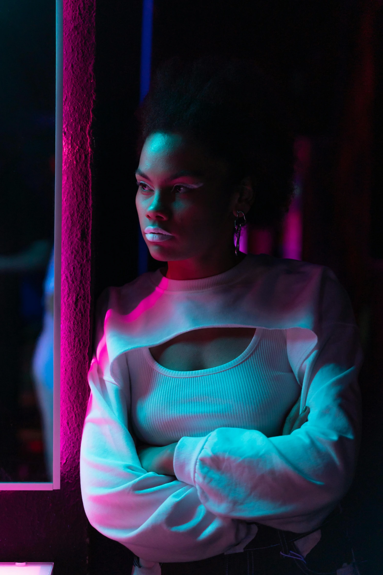 a woman standing in front of a mirror in a dark room, an album cover, inspired by Elsa Bleda, trending on pexels, african american woman, in a nightclub, looking menacing, screenshot from a movie