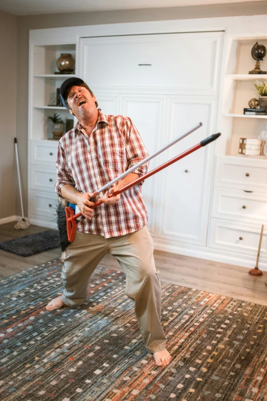 a man holding a baseball bat in a living room, an album cover, by Robert Medley, unsplash, happening, dancing a jig, high quality photo, silly, on a checkered floor