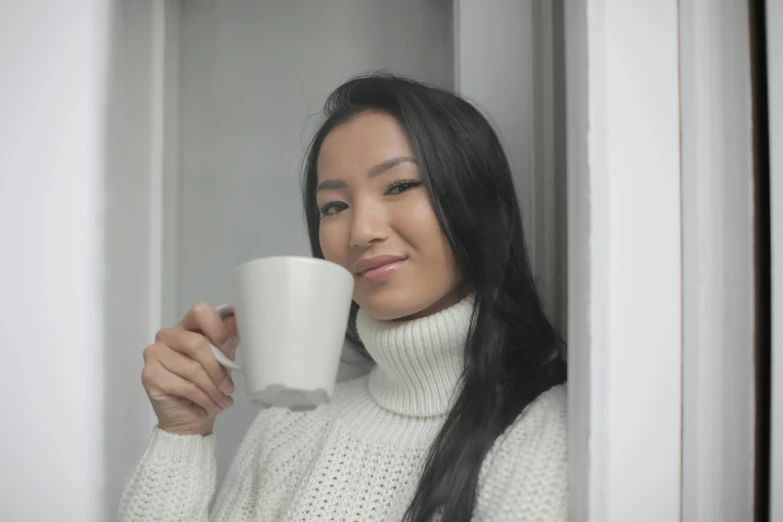 a woman is drinking a cup of coffee, inspired by helen huang, pexels contest winner, hurufiyya, avatar image, white sweater, asian face, peruvian looking