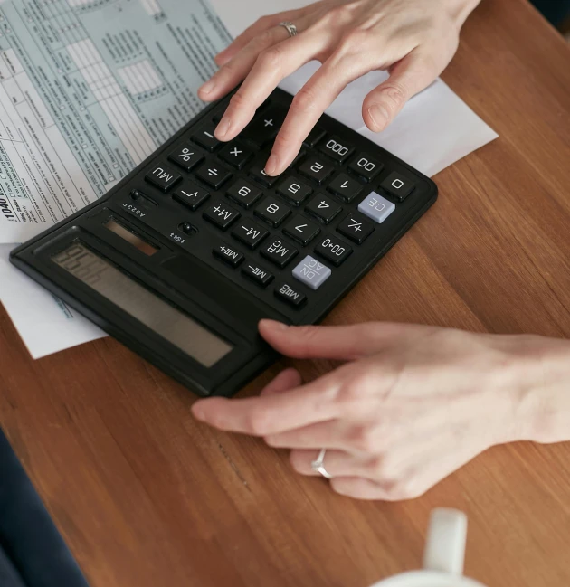 a close up of a person using a calculator, pexels contest winner, sitting on top a table, christina kritkou, katey truhn, thumbnail