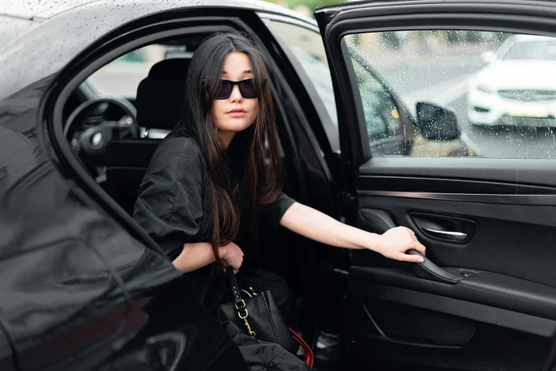 a woman getting out of a car in the rain, pexels contest winner, wearing black stylish clothing, long straight black hair, designer sunglasses, marie - gabrielle capet style