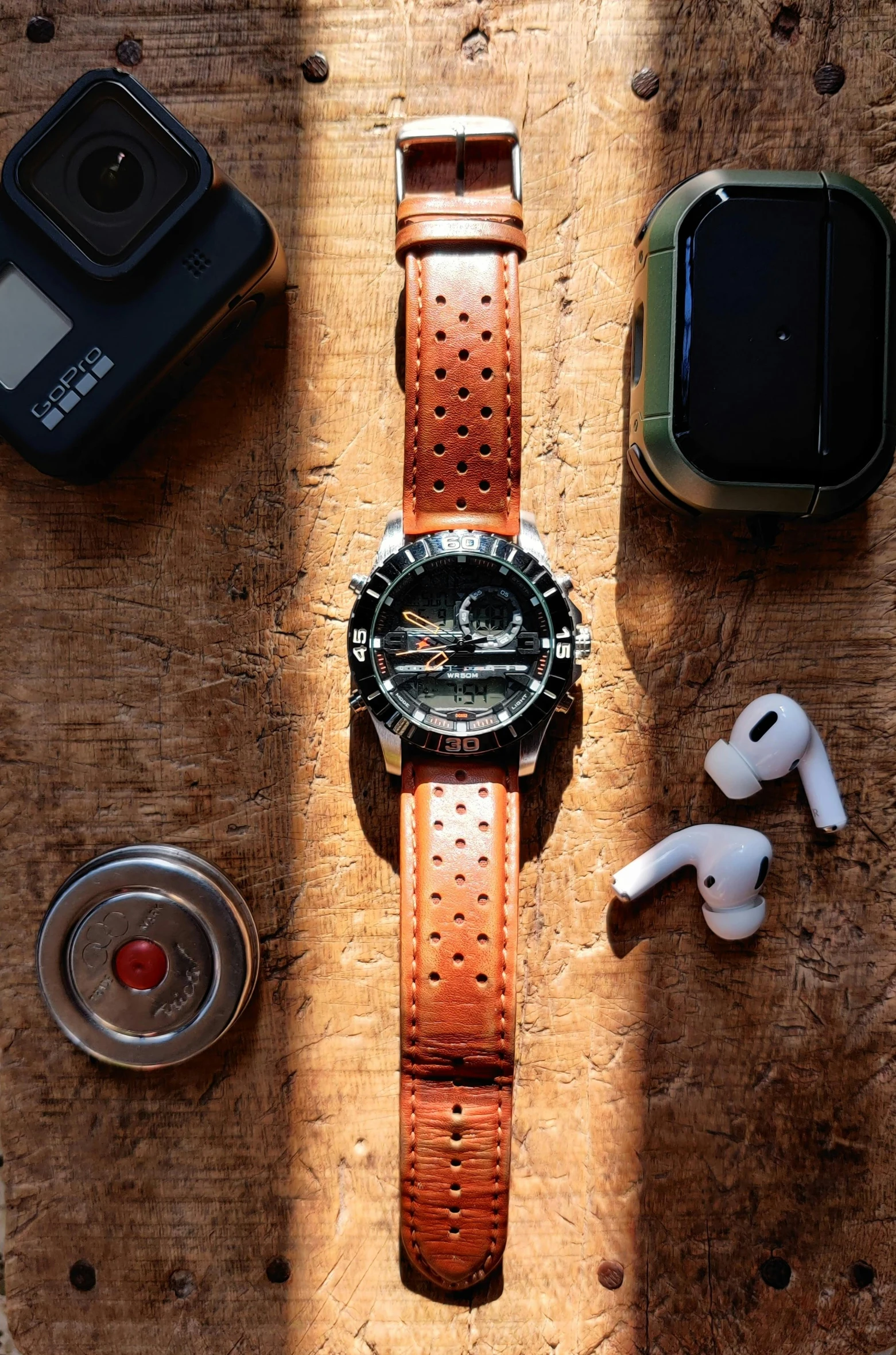 a watch sitting on top of a wooden table next to ear buds, a portrait, samurai jetstream sam, explorer, wearing leather, ar