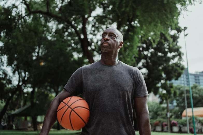 a man holding a basketball in a park, lance reddick, wearing a muscle tee shirt, 15081959 21121991 01012000 4k, ( ( dark skin ) )