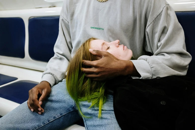 a man sitting next to a woman on a train, inspired by Ren Hang, trending on unsplash, synchromism, green feathery hair, passed out, jesus hugging a woman, green and black