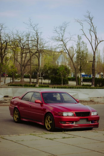 a red car parked on the side of the road, inspired by Zou Yigui, pexels contest winner, realism, toyota jzx 1 0 0 drift, tehran, front view 1 9 9 0, yellowed