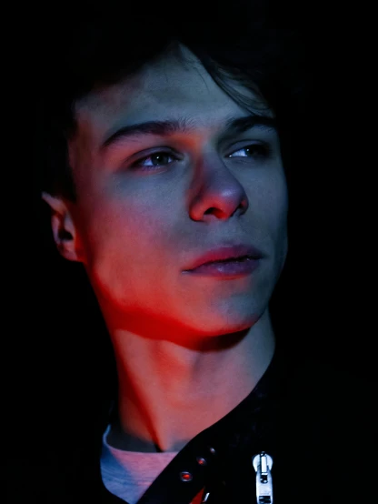 a close up of a person in a dark room, an album cover, inspired by Kristian Kreković, trending on pexels, attractive androgynous humanoid, red lights, self - satisfied smirk, profile picture 1024px