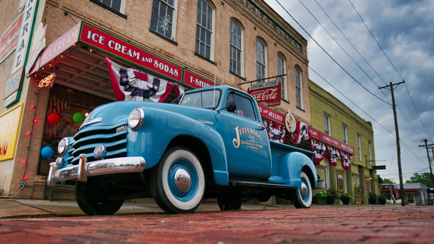 a blue truck parked in front of a building, by Jim Nelson, pexels contest winner, taken in silver dollar city, driving through a 1 9 5 0 s town, jasmine, square