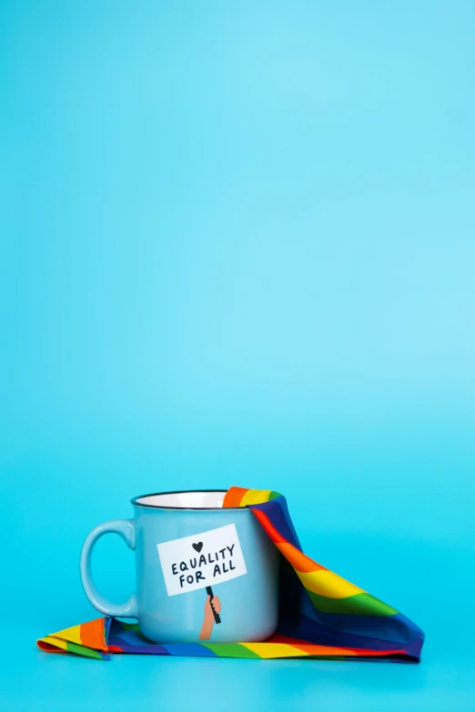 a coffee cup sitting on top of a colorful napkin, an album cover, inspired by Okuda Gensō, pexels, lgbt flag, teal color graded, mug shot, humanity