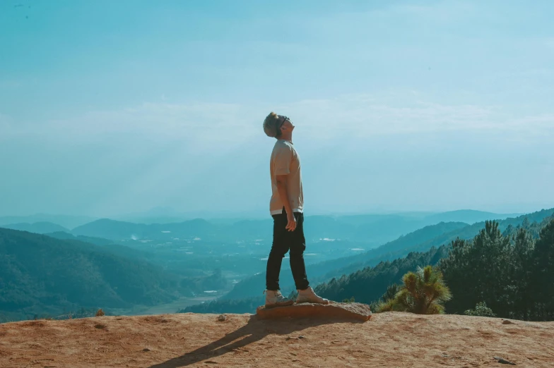 a man standing on top of a rock on top of a mountain, unsplash contest winner, sumatraism, full body profile pose, avatar image, malibu canyon, teenage boy