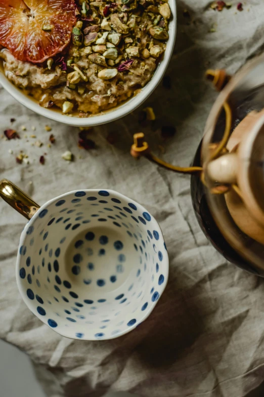 a bowl of oatmeal sitting on top of a table, by Julia Pishtar, trending on unsplash, renaissance, moroccan tea set, polka dot, thumbnail, detail shot