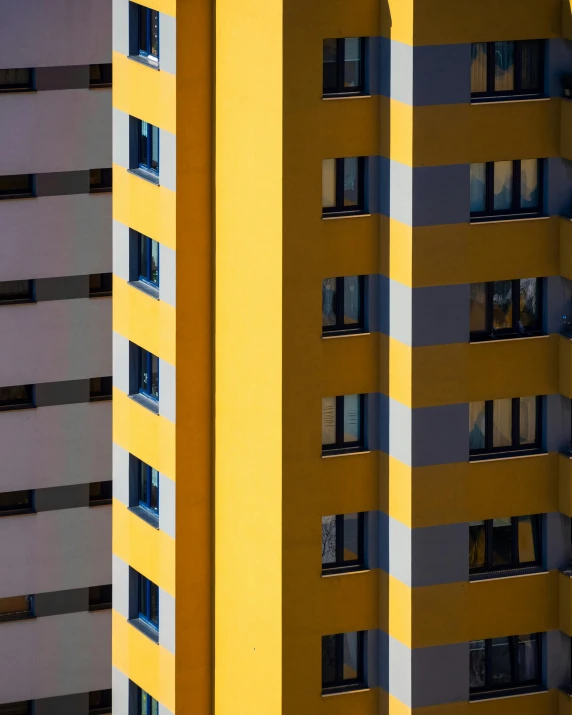 a couple of tall buildings next to each other, by Sven Erixson, unsplash contest winner, colors: yellow, crenellated balconies, close - up portrait shot, multiple stories