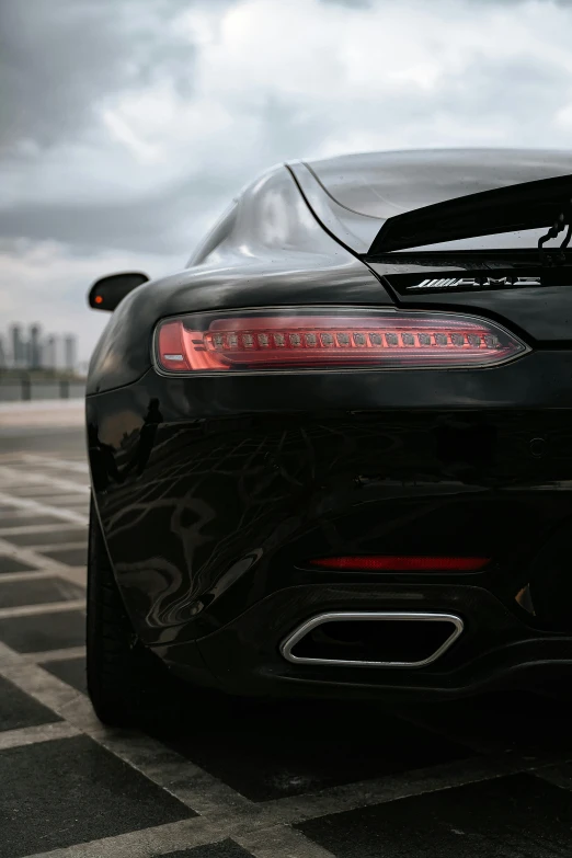 a black sports car parked in a parking lot, inspired by Harry Haenigsen, pexels contest winner, tail lights, morning detail, chiron, aftermarket parts
