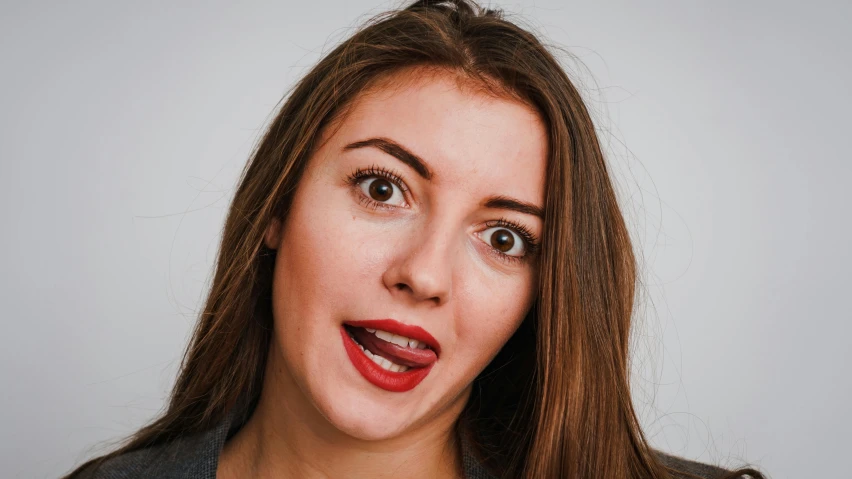 a woman with a surprised look on her face, by Julia Pishtar, trending on pexels, hurufiyya, center parted brown hair, large tongue, mrs bean, h3h3