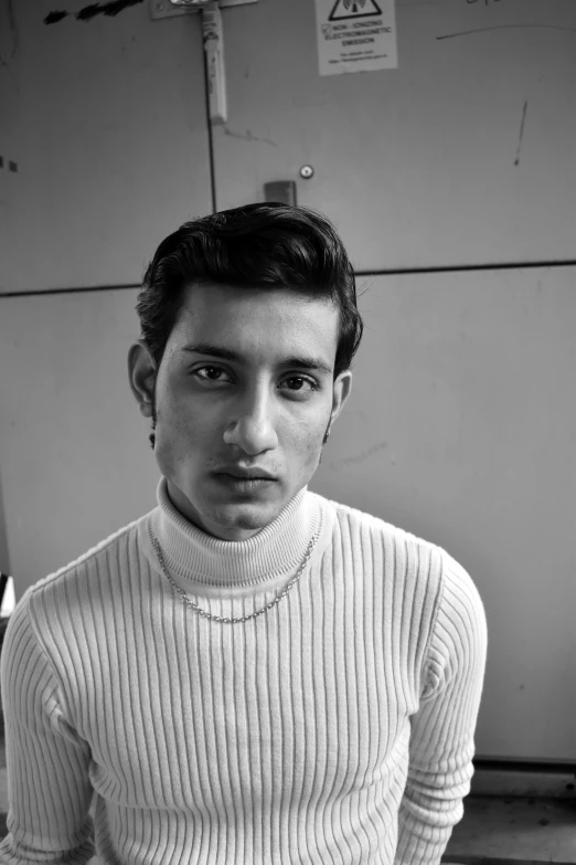 a black and white photo of a man in a sweater, inspired by Narayan Shridhar Bendre, long neck, 18 years old, pompadour, karim rashid