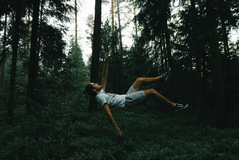 a man flying through the air in a forest, by Caspar Wolf, pexels contest winner, laying down, avatar image, cute photo, 90's photo