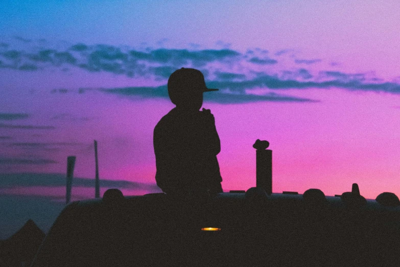 a silhouette of a person standing in front of a sunset, an album cover, pexels contest winner, outdoor rave, sitting on top a table, distant thoughtful look, purple sky