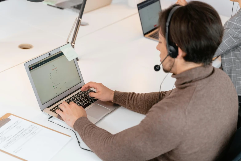 a man sitting at a desk using a laptop computer, by Matthias Stom, pexels, working in a call center, avatar image