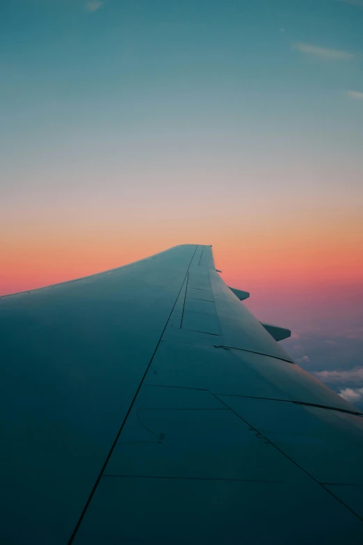 the wing of an airplane as the sun sets, pexels contest winner, aestheticism, pink and blue gradients, plain background, conde nast traveler photo, teal aesthetic