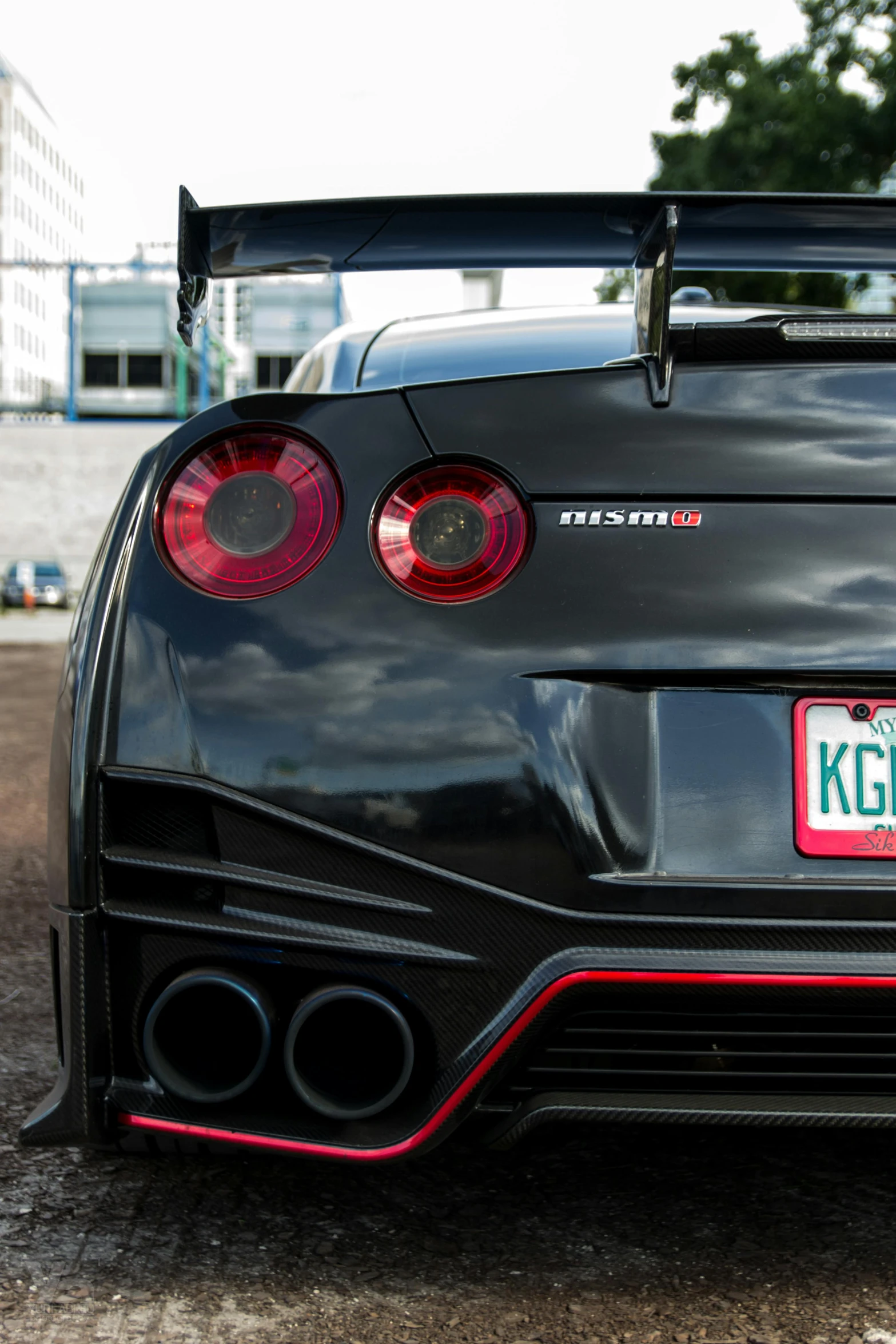 a black sports car parked in a parking lot, red tail lights, gtr xu1, up-close, fujifilm”