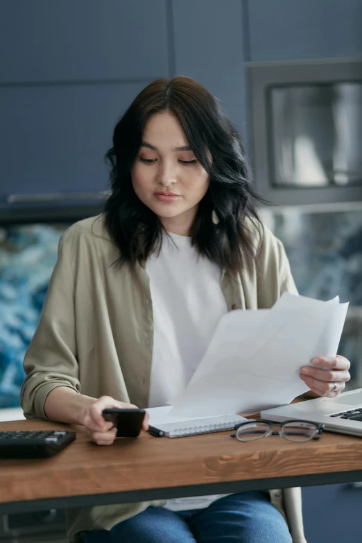 a woman sitting at a table with a laptop and a cell phone, layered paper, professional grade, curated collections, asian human