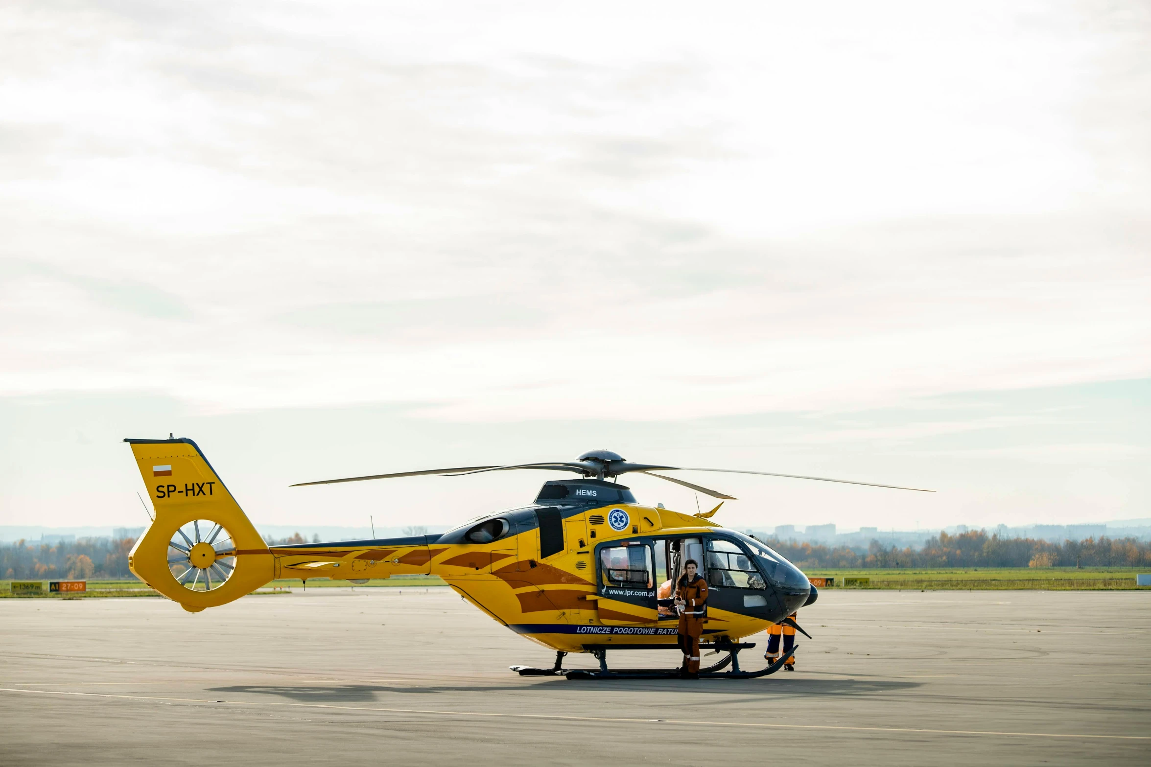 a yellow helicopter sitting on top of an airport tarmac, by Matthias Stom, happening, healthcare, profile image, full body image, 🦩🪐🐞👩🏻🦳