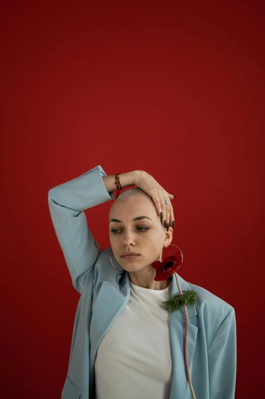 a woman with a rose in her hair, an album cover, inspired by Elsa Bleda, trending on pexels, antipodeans, shaved head, red suit, casual pose, holiday