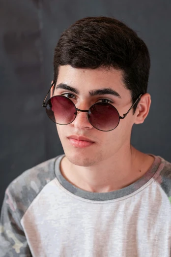 a young man wearing sunglasses posing for a picture, by Emanuel Witz, trending on pexels, photorealism, an epic non - binary model, middle eastern skin, circular sunglasses, male teenager
