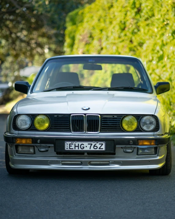 a couple of cars parked next to each other on a street, by Adam Rex, unsplash contest winner, renaissance, bmw e 3 0, front portrait, translucent sss, silver and yellow color scheme