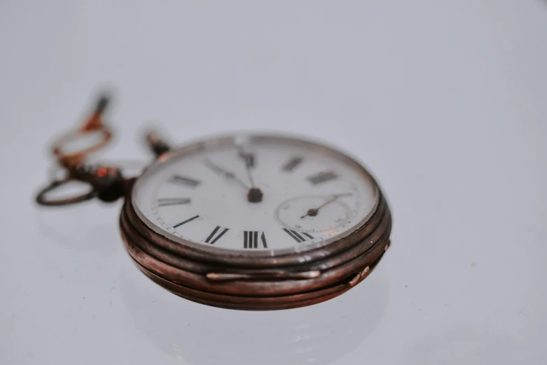 a close up of a pocket watch on a table, an album cover, trending on pexels, hyperrealism, white backround, an unknown ethnographic object, brown, device