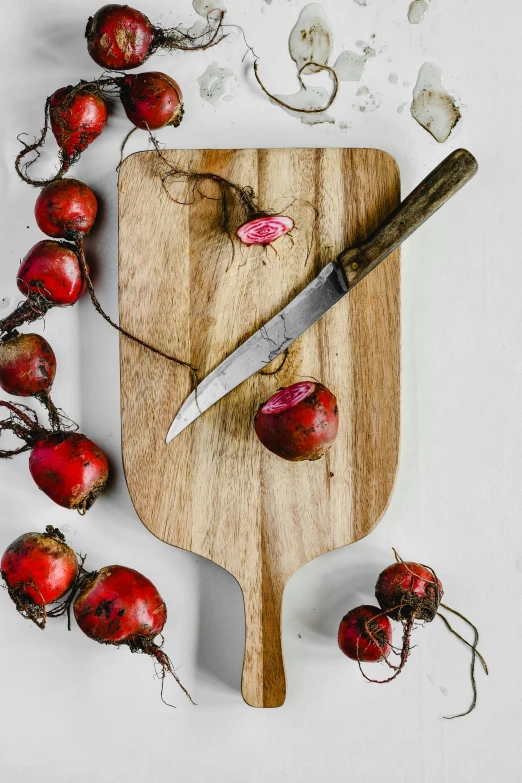 a cutting board with some radishes and a knife, unsplash, renaissance, striking pose, holiday season, 2019 trending photo, petite