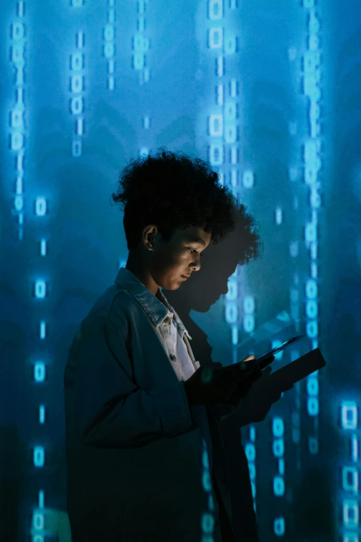 a man standing in front of a computer screen holding a tablet, by Adam Marczyński, pexels, digital art, female cyborg in data center, afro tech, mathematical, backlit