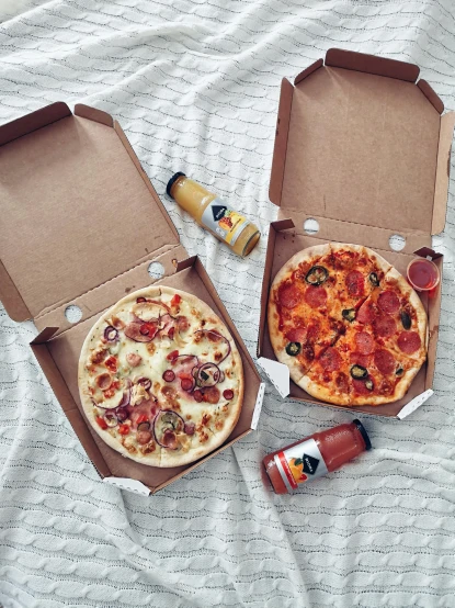 two boxes of pizza sitting on top of a bed, by Julia Pishtar, sauce, flat lay, fully decorated, date