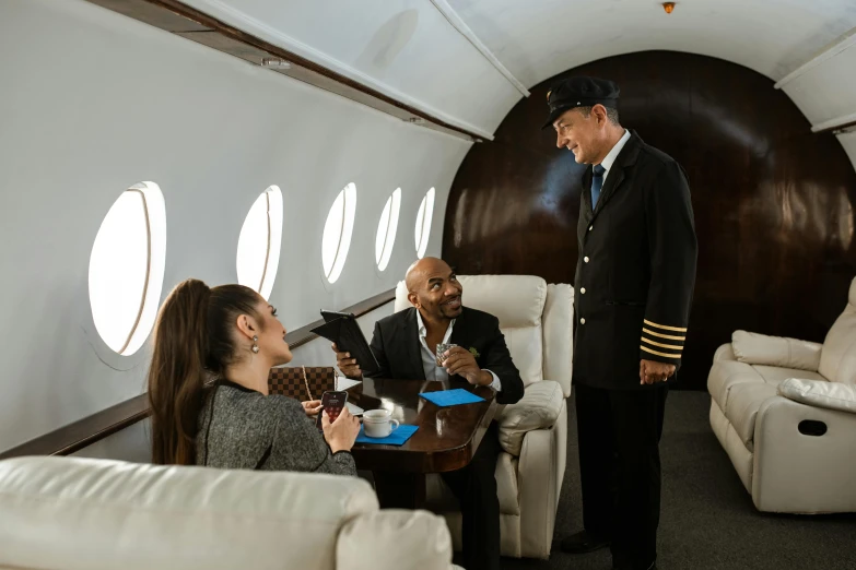 a group of people sitting around a table in an airplane, luxurious environment, captain, avatar image, thumbnail