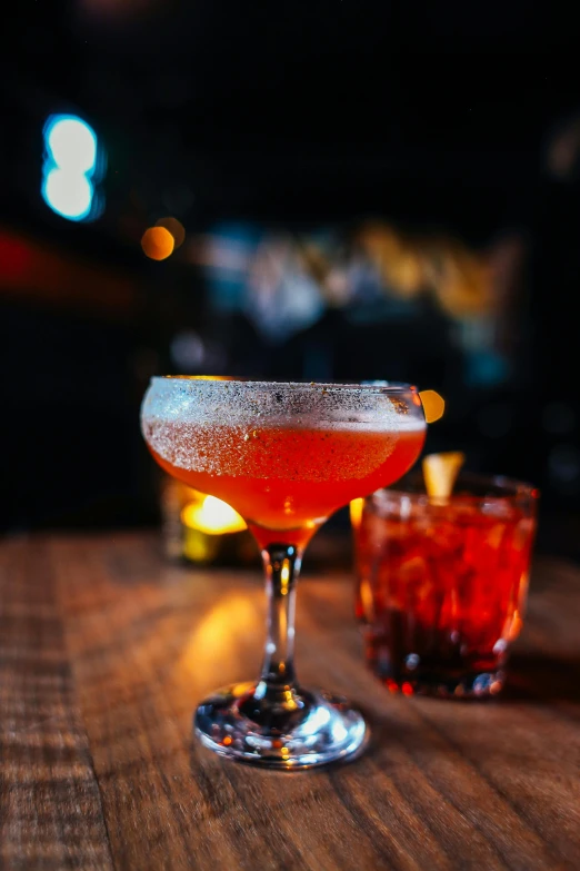 a cocktail sitting on top of a wooden table, by Matt Cavotta, unsplash, renaissance, speakeasy bar background, red caviar instead of sand, thumbnail, 2 9 years old
